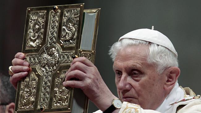 Benedict XVI holds up the book of the Gospels during the Easter Vigil Mass in 2011.