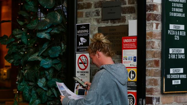 A woman scans a QR code to sign in at the Village Crow pub in Sydney. Picture: NCA NewsWire / Gaye Gerard