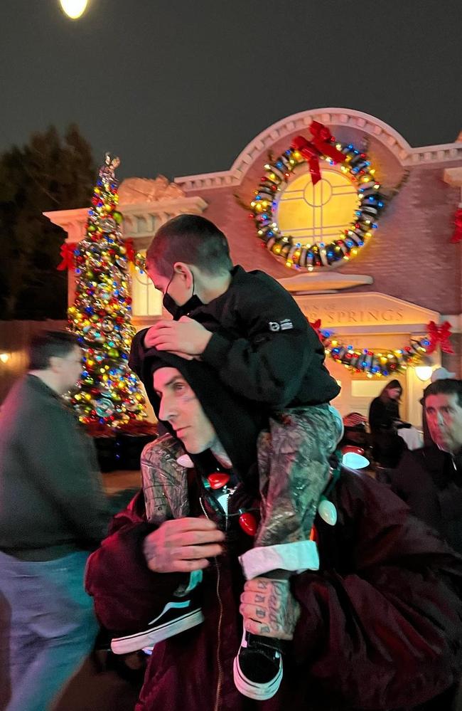 Travis carries Reign on his shoulders through the park.