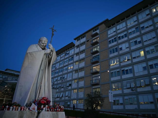 Candles are laid at the statue of John Paul II outside the Gemelli hospital where Pope Francis is being treated. Picture: AFP