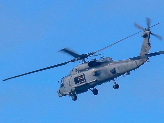 This handout photo taken on July 29, 2023 and received on July 30 from the Australian Defence shows a Royal Australian Navy helicopter conduct search and rescue operations in the vicinity of Lindeman Island, Queensland. Australia's military will ground its fleet of MRH-90 Taipan helicopters after a crash during multinational military exercises that left four crew members missing, the army chief said on July 30. (Photo by AUSTRALIAN DEFENCE / AFP) / ----EDITORS NOTE ----RESTRICTED TO EDITORIAL USE MANDATORY CREDIT " AFP PHOTO / AUSTRALIAN DEFENCE" NO MARKETING NO ADVERTISING CAMPAIGNS - DISTRIBUTED AS A SERVICE TO CLIENTS