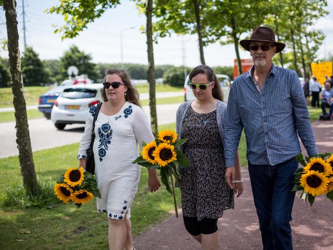 People carrying flowers as they arrive at a service to mark the three year anniversary of the downing of MH17 near Amsterdam's Schiphol Airport.