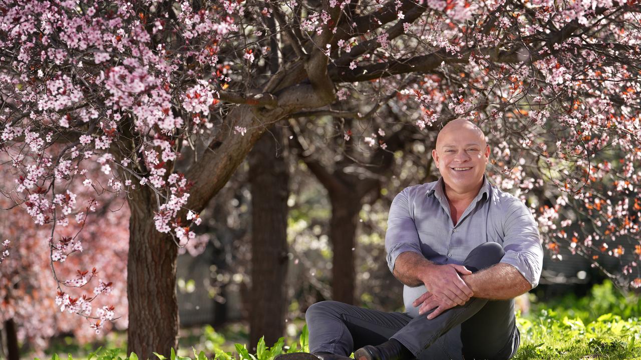 Meteorologist Darren Ray among the springtime cherry blossoms at Penfold Park. Picture: Dean Martin