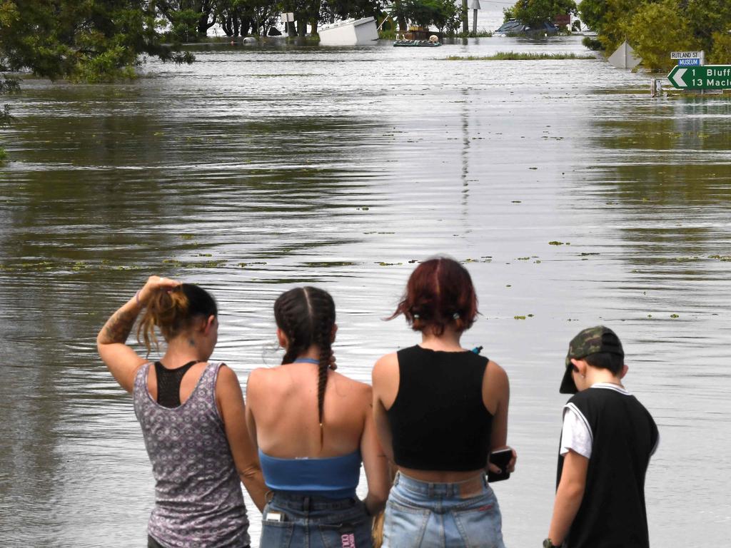 Residents stand by a flooded street in the NSW town of Lawrence. Picture: Saeed Khan/AFP