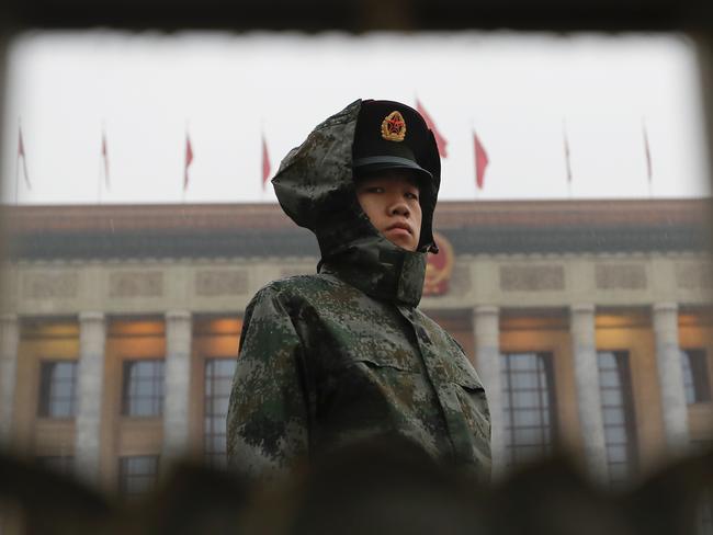 A solder in a raincoat stands watch outside the Great Hall of the People during the opening ceremony of the 19th Party Congress in Beijing. Picture: Andy Wong/AP