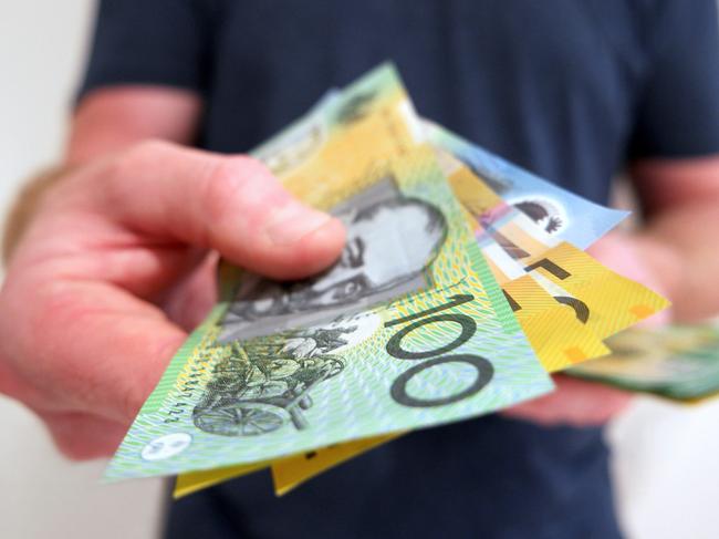 A man handing out Australian dollar bills. A picture that describes buying, paying, handing out money, or showing money.