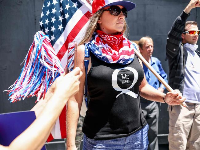 (FILES) In this file photo taken on May 1, 2020 Conspiracy theorist QAnon demonstrators protest during a rally to re-open California and against Stay-At-Home directives in San Diego, California. - Twitter has removed more than 7,000 accounts linked to the "QAnon" movement over abuse and harassment concerns, saying July 21, it will limit the spread of conspiracy theories by its supporters. (Photo by Sandy Huffaker / AFP)