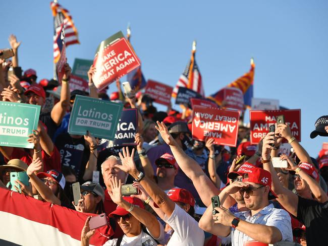 Supporters without face masks wave at Donald Trump as he departs following a rally at Tucson International Airport in Tucson, Arizona. Picture: AFP