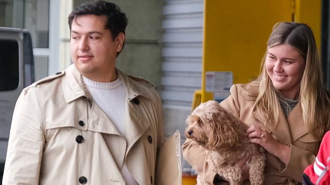 Brittany Higgins and David Sharaz cuddle their cavapoodle dog Kingston and carry their cat Clover after the animals cleared quarantine at the Bordeaux-Merignac airport in France. Picture: Jacquelin Magnay