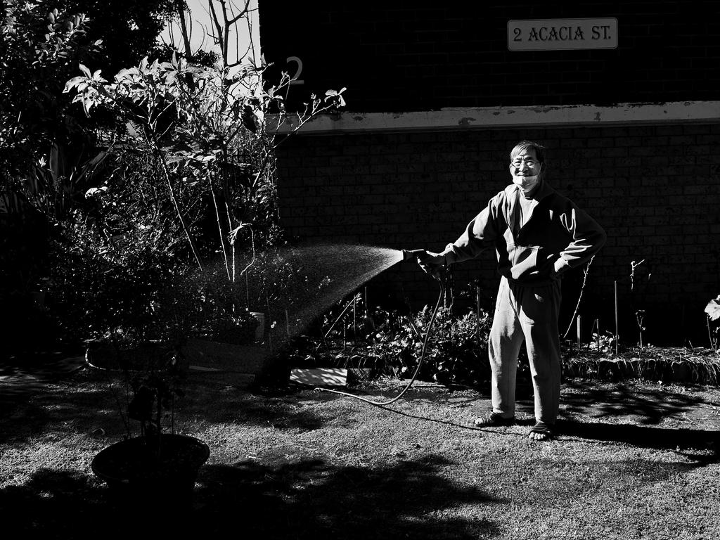 FACES OF LOCKDOWN: Quang Nguyen, 75 years old, waters his garden in Cabramatta. Photo: Jeremy Piper