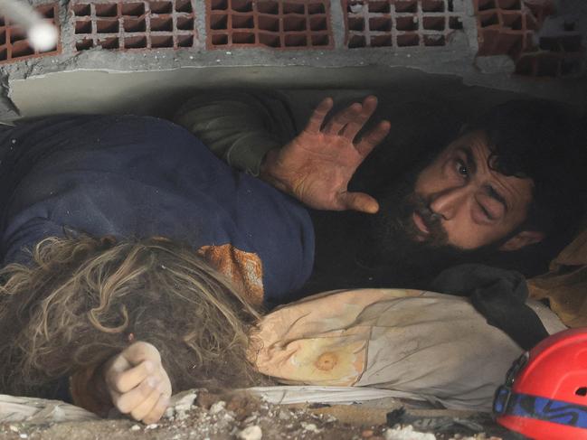 Abdulalim Muaini lies under the rubble next to the body of his wife Esra, in the aftermath of a deadly earthquake in Hatay, Turkey. Picture: Reuters/Umit Bektas