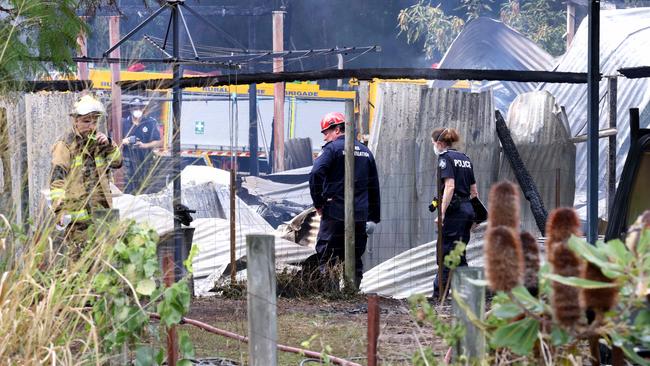 Firefighters and police inspect one of the buildings. Picture: Steve Pohlner