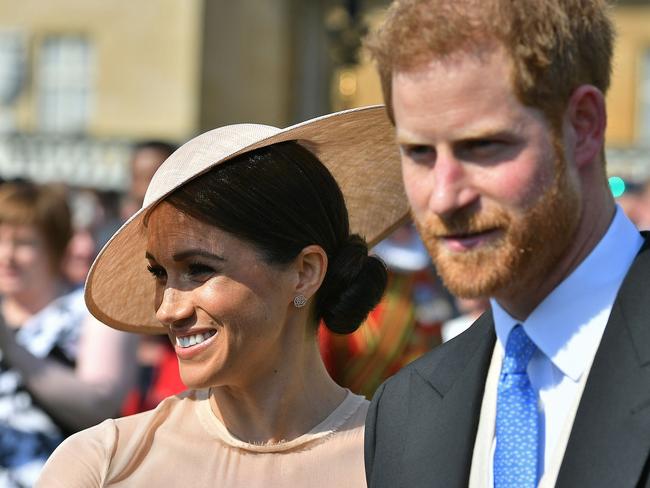 Britain's Prince Harry, Duke of Sussex (R), and his new wife, Britain's Meghan, Duchess of Sussex, attend the Prince of Wales's 70th Birthday Garden Party at Buckingham Palace in London on May 22, 2018. The Prince of Wales and The Duchess of Cornwall hosted a Garden Party to celebrate the work of The Prince's Charities in the year of Prince Charles's 70th Birthday. / AFP PHOTO / POOL / Dominic Lipinski