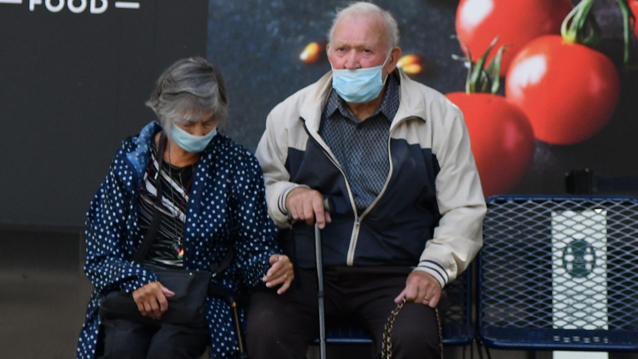 An elderly couple wearing protective face masks sit outside a M &amp; S store in Birmingham, central England on August 22, 2020. Men have a higher chance of having adverse effects from COVID-19 than women the same age. Picture: Justin Tallis / AFP