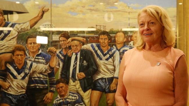 Lynne Anderson, the daughter of Canterbury patriarch Peter Moore poses next to a painting of her father after the Canterbury board elections, where it was announced she is set to take the place of Ray Dib as Chairman of the Bulldogs.