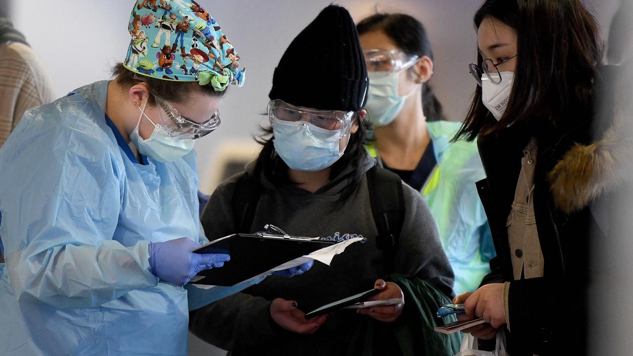 NSW Health workers dressed in Personal Protective Equipment (PPE) are seen screening passengers in July 2020 as they disembarked a fight, at Sydney Airport. Picture: NCA NewsWire / Bianca De Marchi