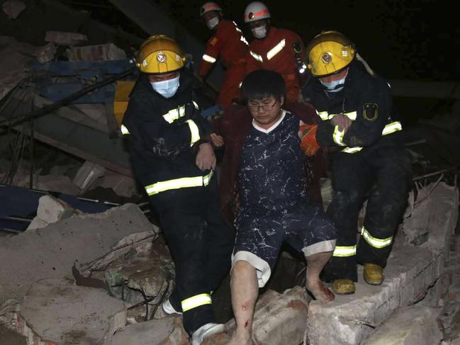 Rescuers help a man from the rubble of a collapsed hotel building in Quanzhou city. Picture: AP