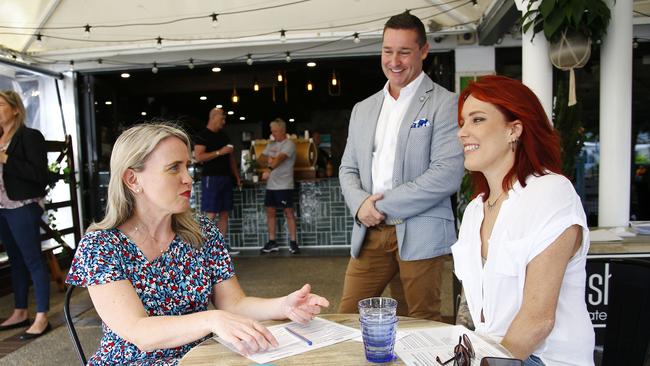 Tourism Minister Kate Jones fills out the new government required form for diners at the Hot Shott cafe with owner Jenna Finch. Picture: Tertius Pickard.