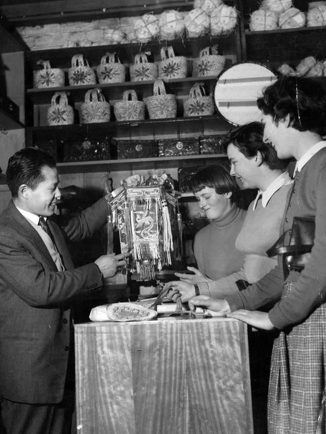 A shopkeepers showing his wares at a store in Little Bourke St in 1955. Picture: HWT Library.