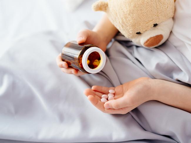 Child taking medicines pills. Sick eight years boy lying in bed patient boy illness drugs istock