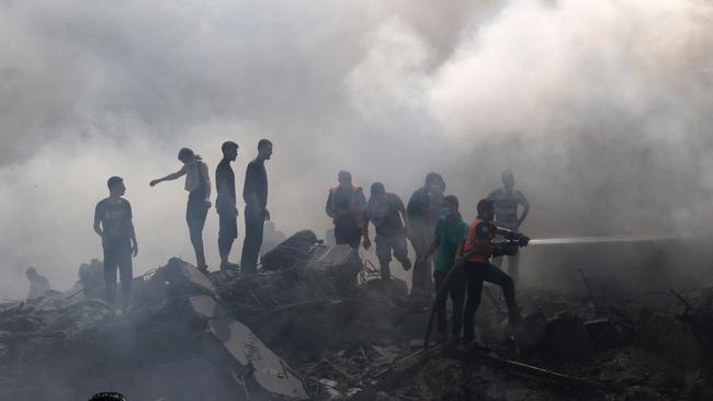 Palestinians stand on the rubble of a building following an Israeli strike in the southern Gaza Strip on October 12, 2023. Picture: SAID KHATIB / AFP