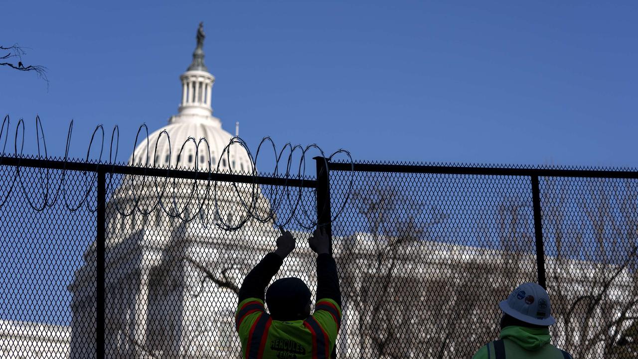 Workers install barbed wire on security fencing surrounding the US Capitol. Picture: Stefani Reynolds/Getty Images/AFP