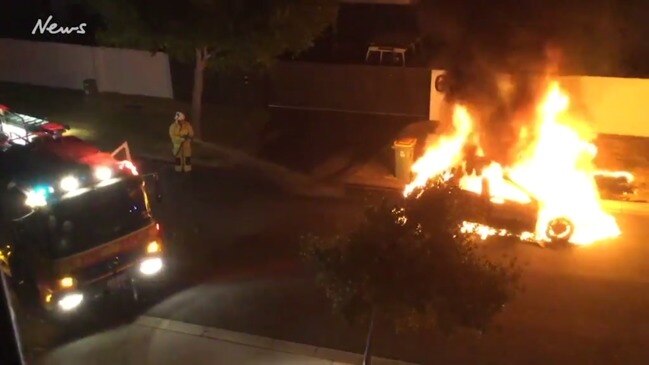 Firemen put out burning car at Biggera Waters