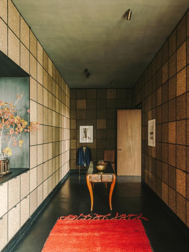 In the dressing room, walls and shelving of recycled cork surround a 1950s Italian table and a Berber carpet. Picture: Salva López for WSJ. Magazine