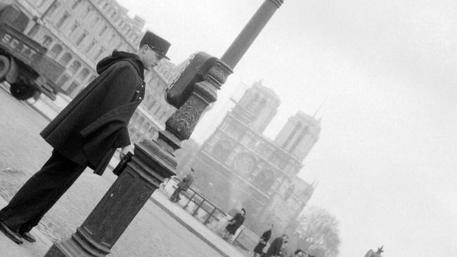 April 01, 1945: A police officer controlling the traffic on the Ile de la Cité near the Notre-Dame cathedral. Picture: AFP 