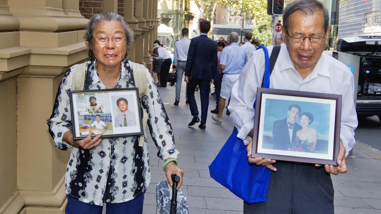 The parents of slain newsagent Min Lin, Yang Fei Lin (left) and Geng Qing Zhu carry photos of their murdered family at Robert Xie’s trial. Picture: Jenny Evans.