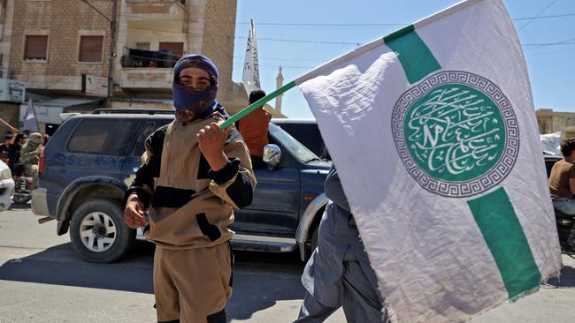 Jihadi group Hayat Tahrir al-Sham (HTS), led by al-Qaeda's former Syria affiliate, holds the group's flag to celebrate the Taliban's declared "Islamic Emirate of Afghanistan" on August 20, 2021. Picture: AFP