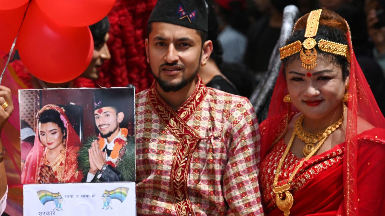 Maya Gurung (R) and Surendra Pandey, wearing traditional attire, take part in a pride parade in Kathmandu on August 31, 2023. (Photo by PRAKASH MATHEMA / AFP)