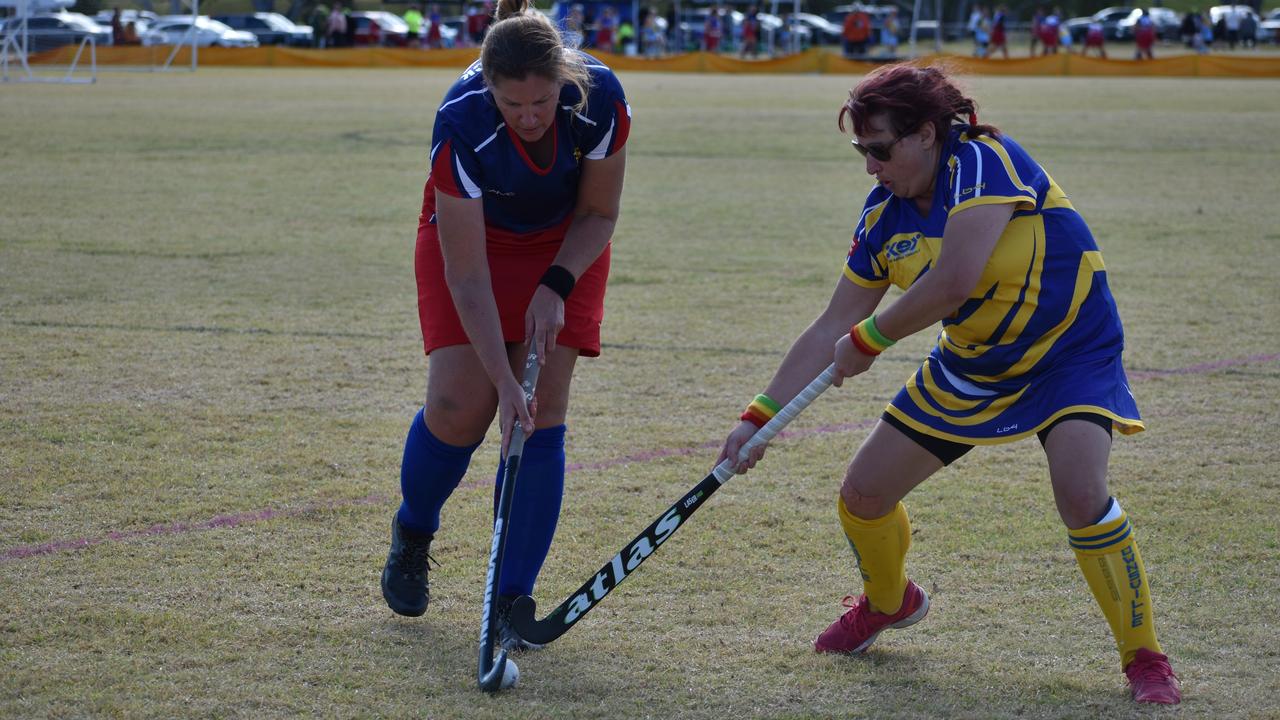 Warwick's Angela Groves and Townsville's Emily Norton battle it out for the ball at the 2021 Queensland Hockey Women's Masters Championship at Queens Park.