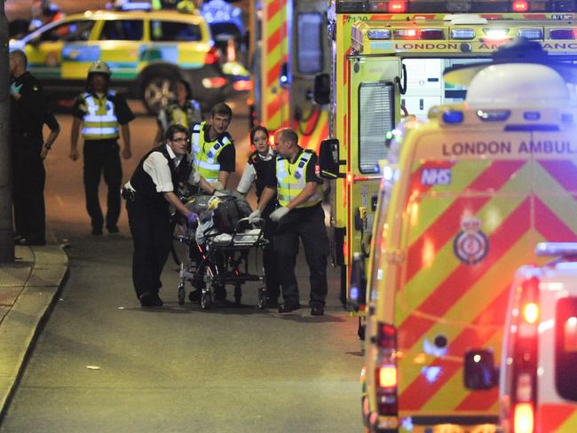 Police officers and members of the emergency services attend to a person injured in a terror attack in London. Picture: AFP