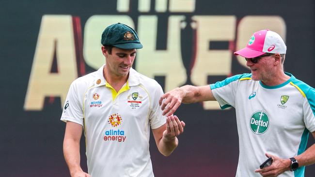 Australia's captain Pat Cummins uses hand sanitiser from a team official during a practice session at the Sydney Cricket Ground Picture: AFP