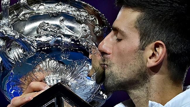 Serbia's Novak Djokovic celebrates with the Norman Brookes Challenge Cup trophy following his victory against Greece's Stefanos Tsitsipas in the men's singles final match on day fourteen of the Australian Open tennis tournament in Melbourne on January 29, 2023. (Photo by MANAN VATSYAYANA / AFP) / -- IMAGE RESTRICTED TO EDITORIAL USE - STRICTLY NO COMMERCIAL USE --