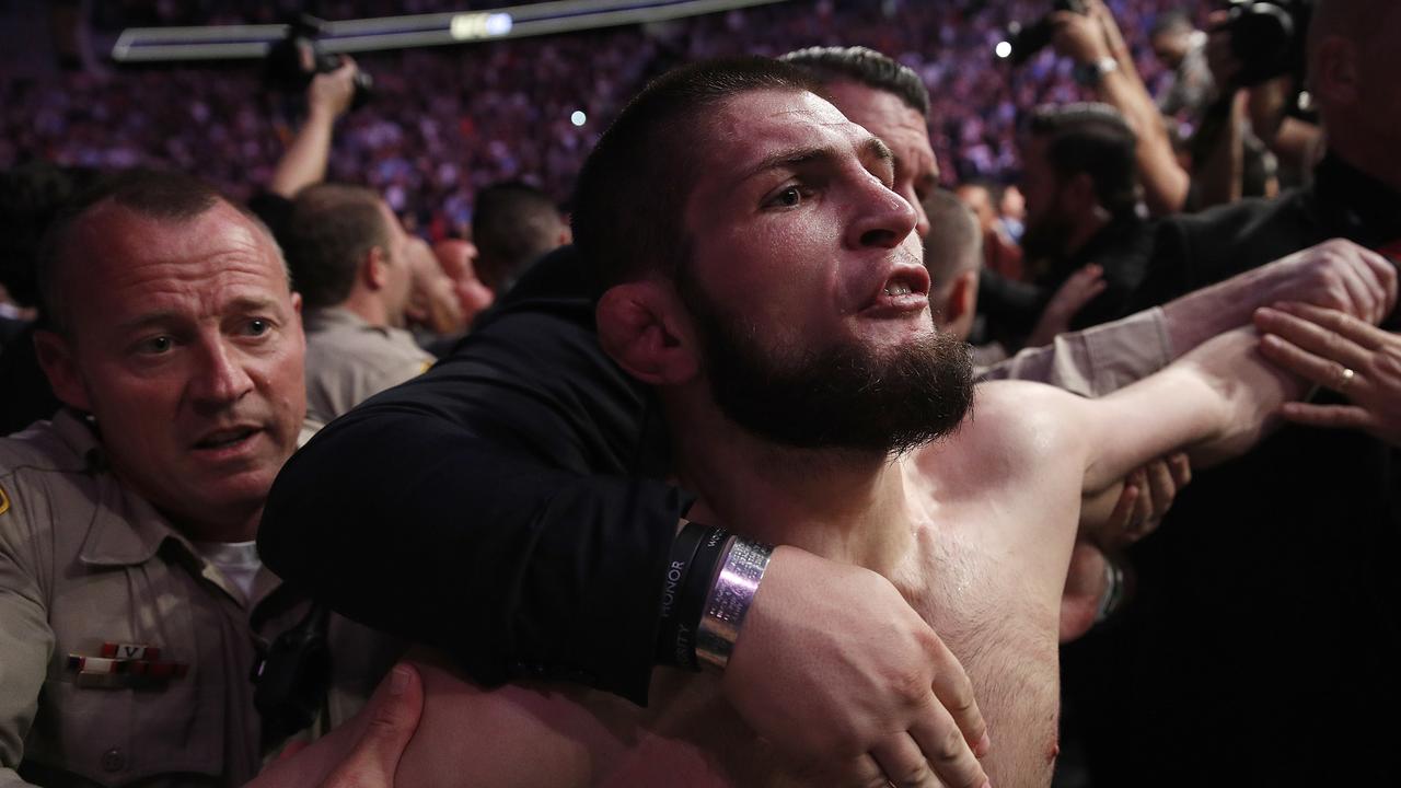 Khabib Nurmagomedov is held back outside of the cage after fighting Conor McGregor.