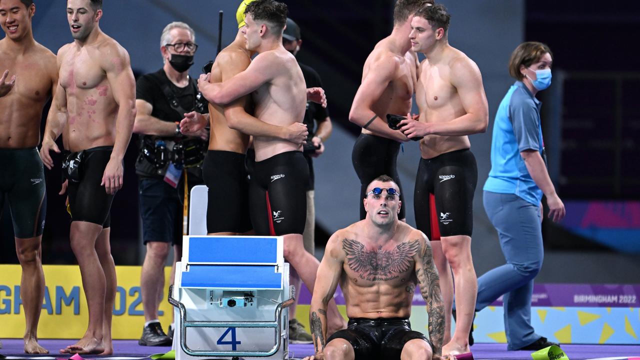 Kyle Chalmers of Australia looks on as athletes congratulate each other following the Men's 4 x 100m Freestyle Relay Final. AAP Image/Dave Hunt.