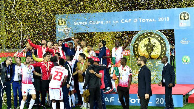 Wydad Casablanca's players celebrate with the champions' trophy after winning a Cup match at the Mohammed V Stadium in Casablanca. / AFP PHOTO / STRINGER