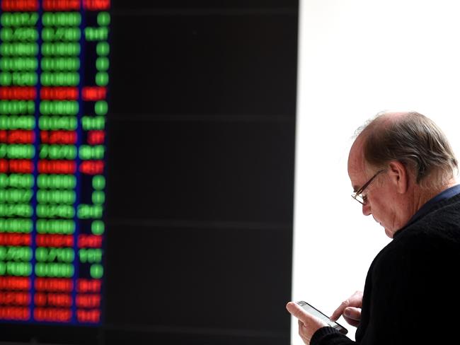 A man watches the ASX trading board in Sydney on Tuesday, Aug. 25, 2015. After an initial 1.5 per cent plunge, the S&P/ASX 200 and the All Ordinaries which pulled both indices below 5,000 points, a recovery among key heavyweight bank stocks pushed the market back into positive territory. (AAP Image/Paul Miller) NO ARCHIVING