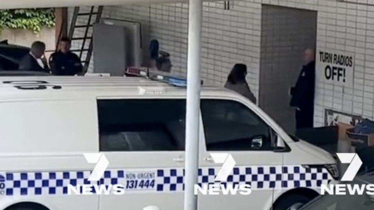 Ms Patterson (in grey) walks into the police station followed by officers. Photo: 7 News