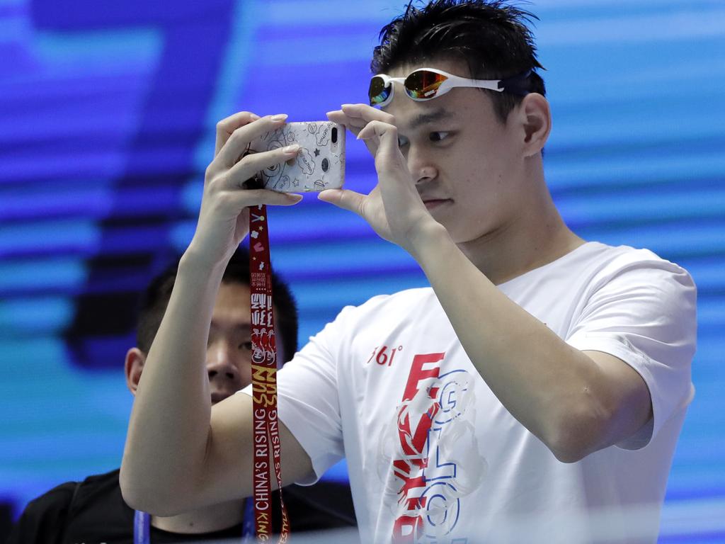 Sun Yang takes photos on the pool deck in Gwangju.