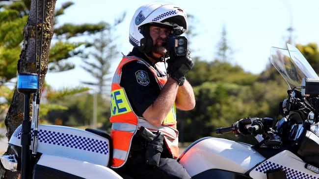 A SAPOL officer uses a laser gun in Taperoo. Picture Simon Cross