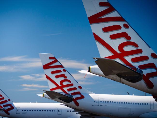 Virgin Australia aircraft are seen parked on the tarmac at Brisbane International airport on April 21, 2020. - Cash-strapped Virgin Australia collapsed on April 21, making it the largest carrier yet to buckle under the strain of the coronavirus pandemic, which has ravaged the global airline industry. (Photo by Patrick HAMILTON / AFP)