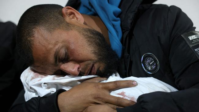 A Palestinian man hugged the body of a baby following overnight air strikes in the northern Gaza Strip, at a hospital in Beit Lahia on Friday. Photo: Bashar Taleb/AFP