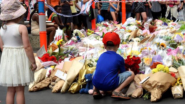 Indiana, 3, and Stevie, 5, lay flowers from their own garden at the floral tribute. Picture: Nicole Garmston