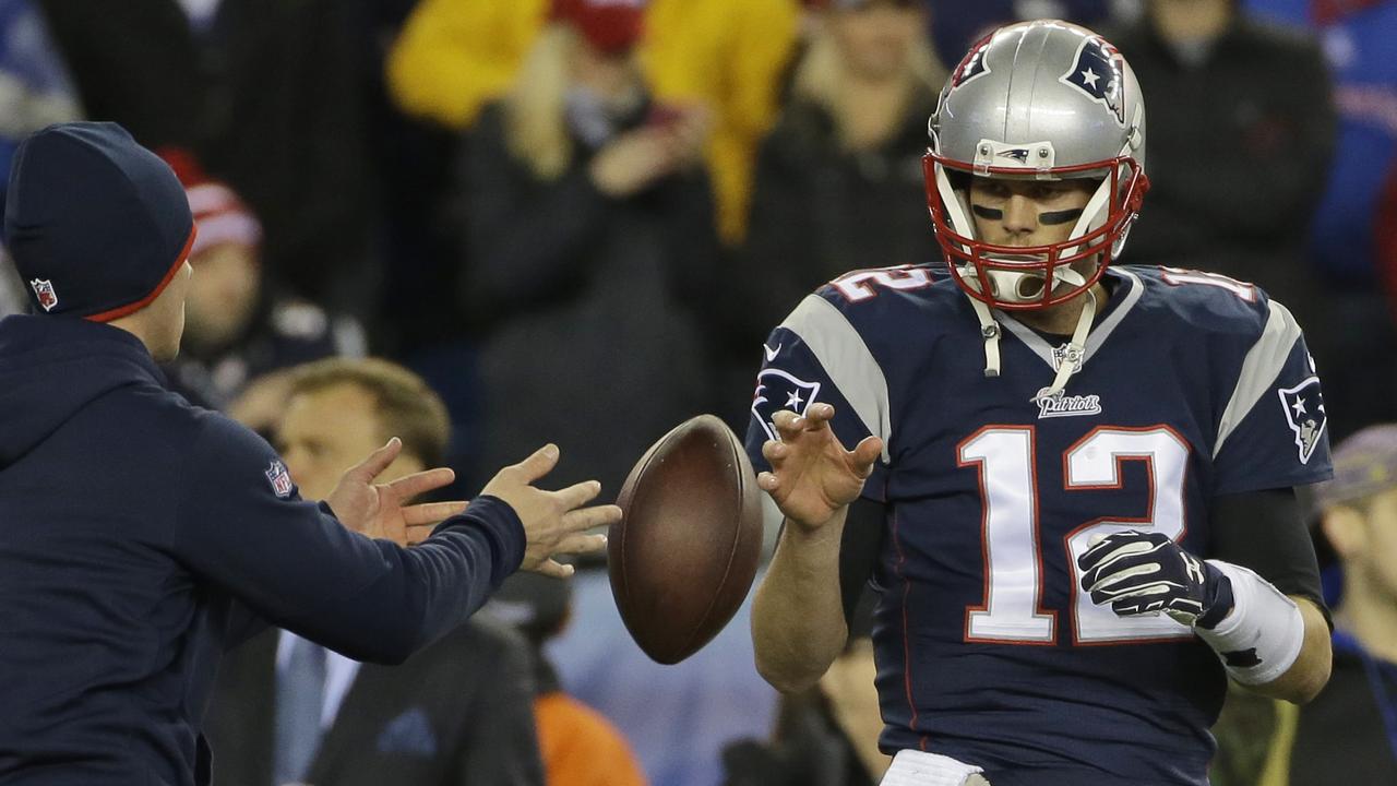 In this Sunday, Jan. 18, 2015, photo New England Patriots quarterback Tom Brady has a ball tossed to him during warmups before the NFL football AFC Championship game against the Indianapolis Colts in Foxborough, Mass. The NFL says its investigation into whether the New England Patriots used underinflated footballs in the AFC championship game is ongoing after a report Tuesday night. Jan. 20, 2015, claimed the league found 11 balls were not properly inflated. (AP Photo/Matt Slocum, File)