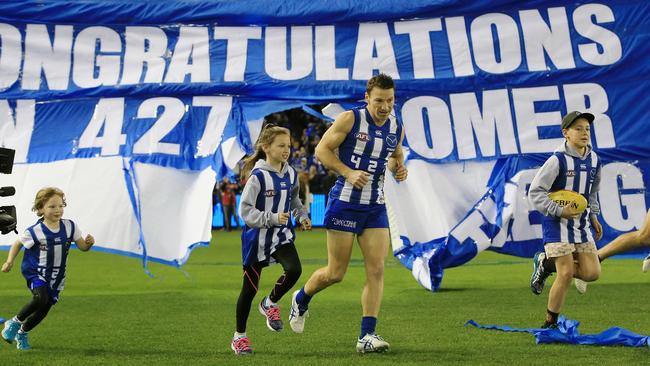 Brent Harvey runs through the banner before this milestone game. Picture: Wayne Ludbey