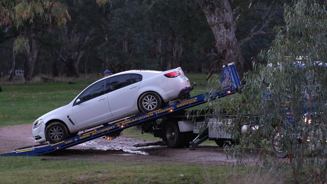 A car is removed by police at the crime scene at Richardsons Bend Campground near Barnawartha North. Picture: Simon Dallinger