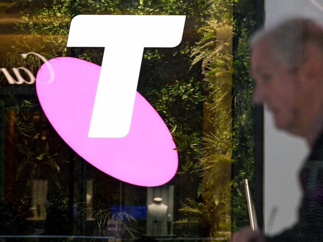 A man walks past the office of Australian telecoms company Telstra in the central business district of Sydney on May 21, 2024. Leading Australian telecoms company Telstra said May 21 it would slash up to 2,800 jobs, shedding nine percent of its workforce as it keeps pace with "rapid advances in technology". (Photo by Saeed KHAN / AFP)